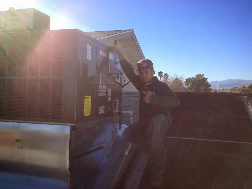 HVAC technician performing AC Tune-Up on a rooftop unit in Charlotte